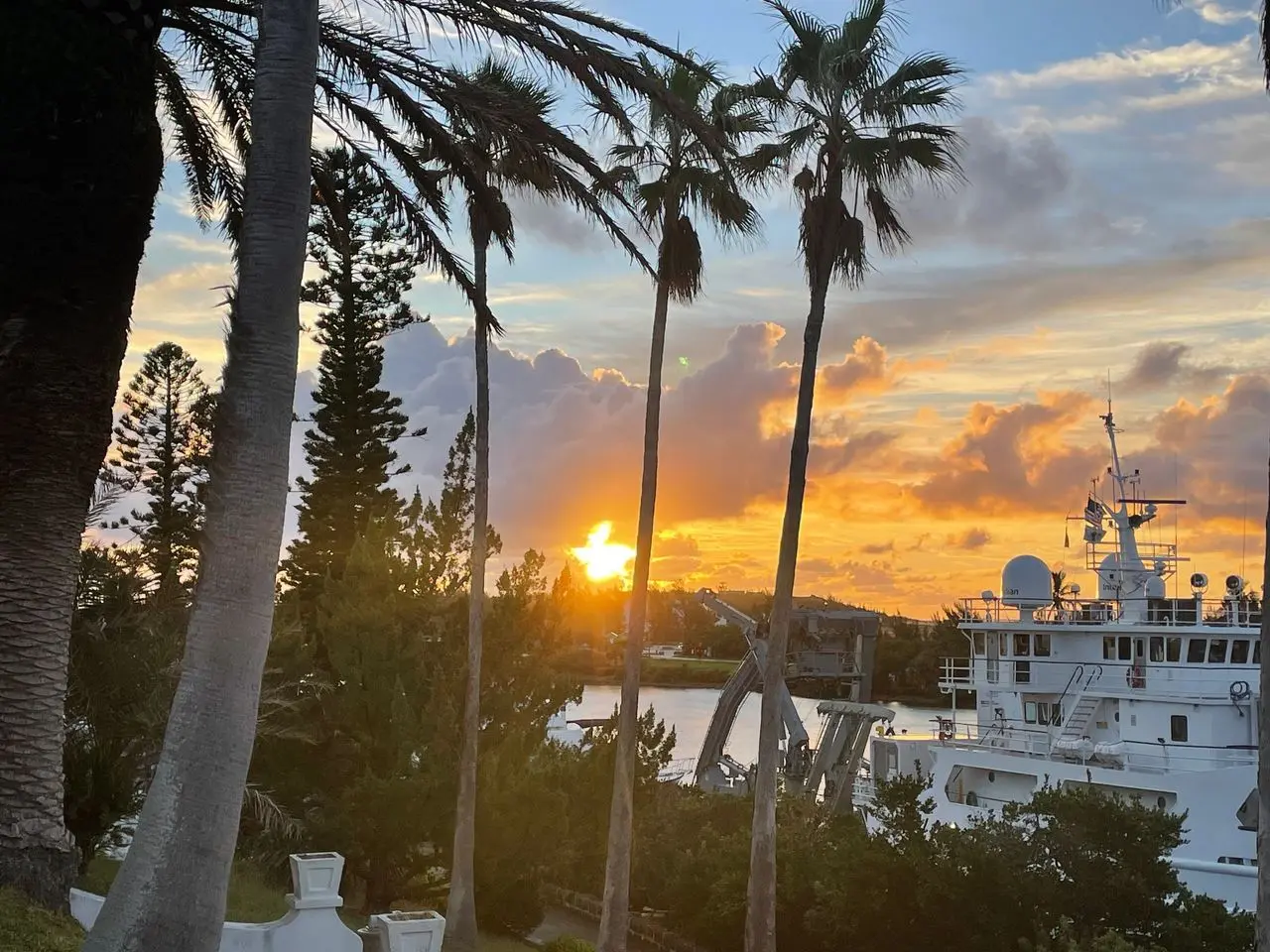 Sunset over harbor with research vessel.