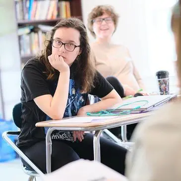 Here's an alt tag for the image, keeping it under 8 words: `Students attentively listening in class`