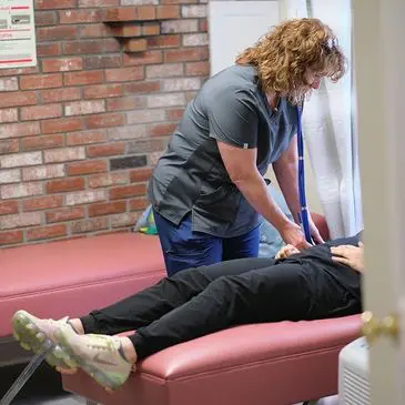 Here's an alt tag for the image: Nurse examining patient on exam table.