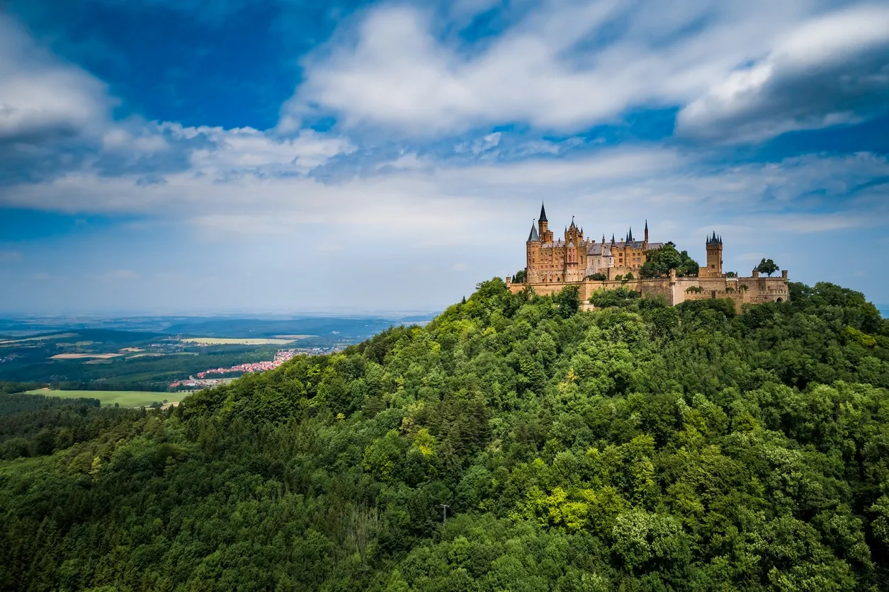 Here's an alt tag for the image: Hohenzollern Castle atop green hill.