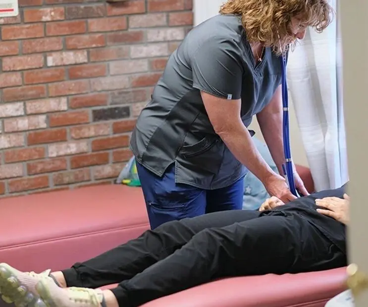 Nurse using stethoscope on patient.