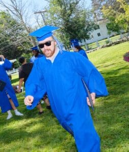 A man in blue graduation gown and cap.