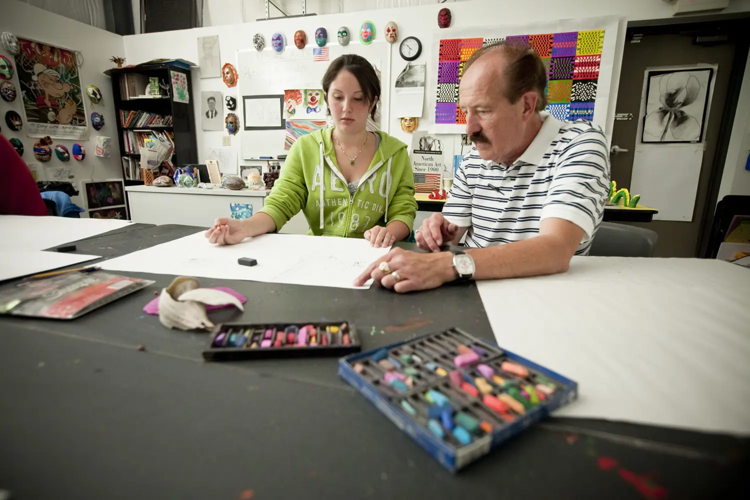 A man and woman sitting at a table with papers.