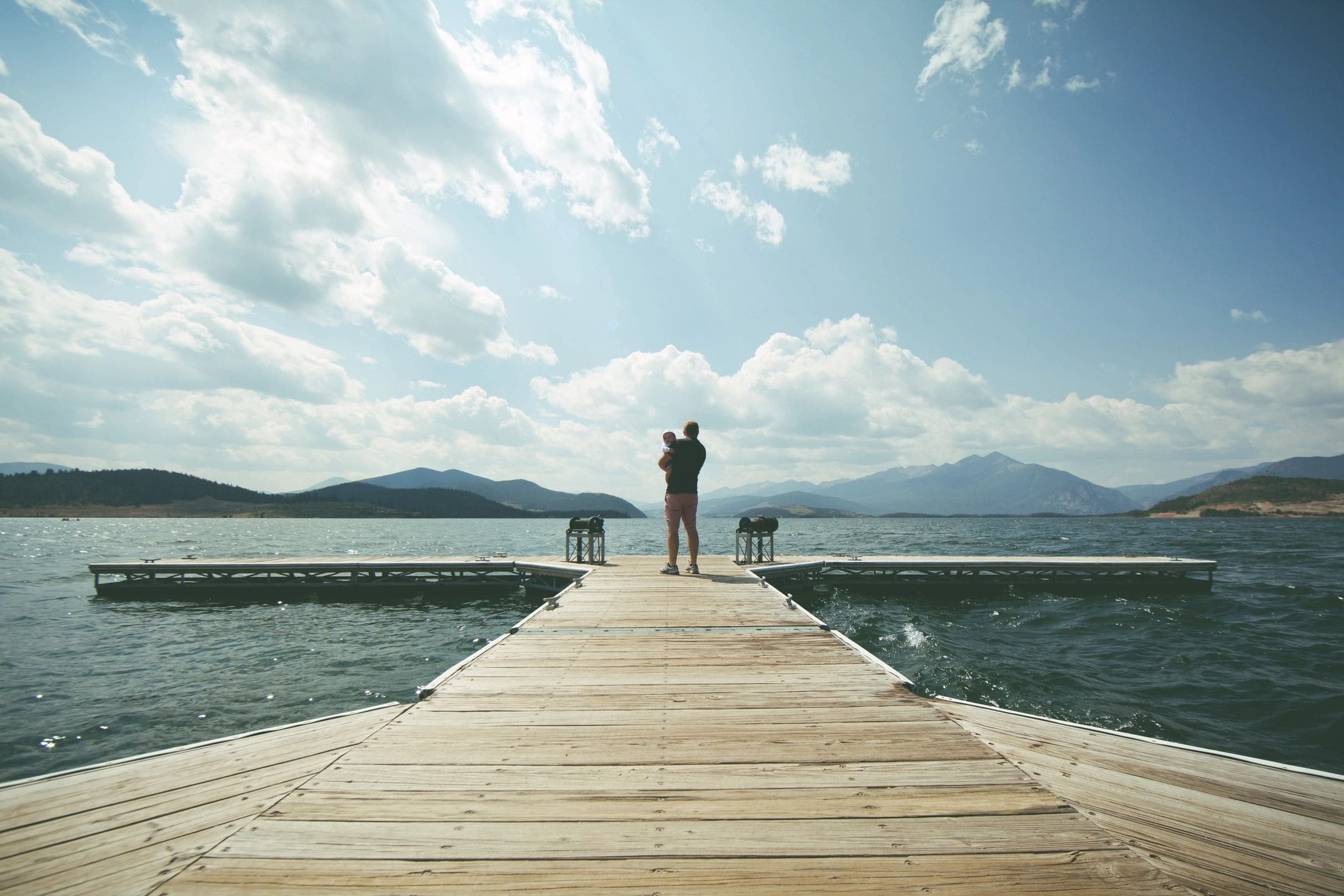 A person standing on the end of a pier.