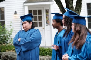 A group of people in blue graduation caps and gowns.