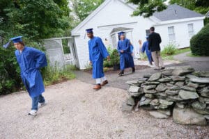 A group of people in blue gowns walking down the street.