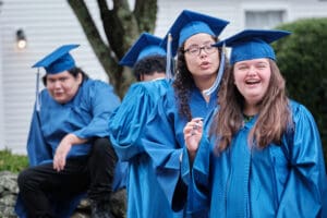 A group of young people in blue graduation gowns.