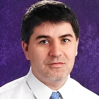 Headshot of a man in a white shirt.