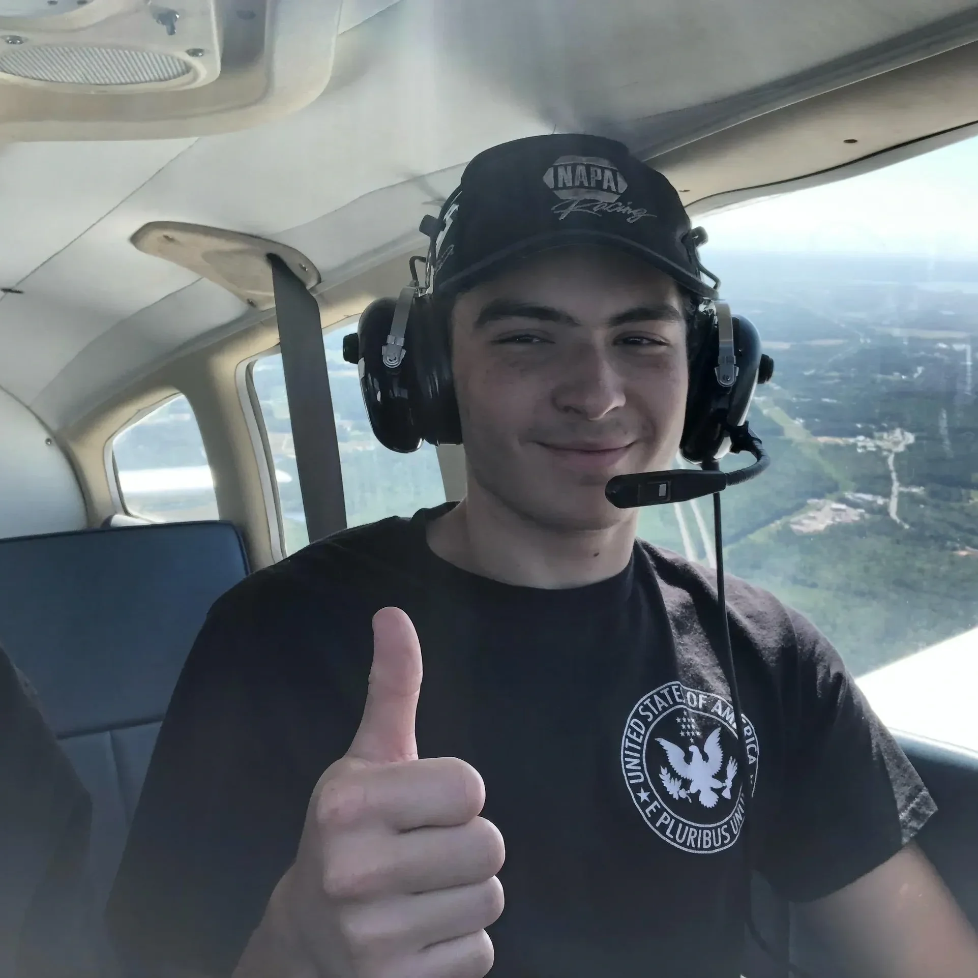 Here's an alt tag for the image: Pilot giving thumbs up in plane.