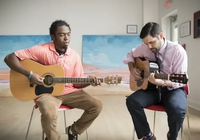 Two men playing acoustic guitars.