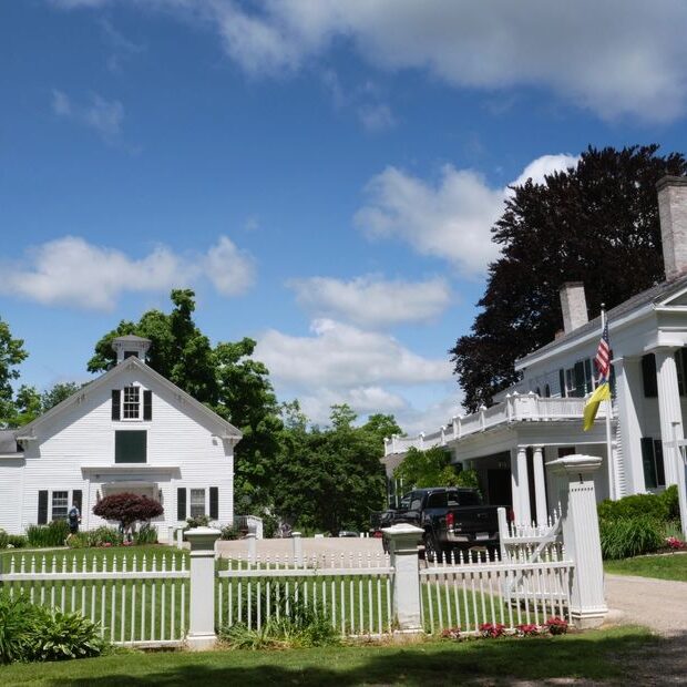 White colonial-style houses with flags.