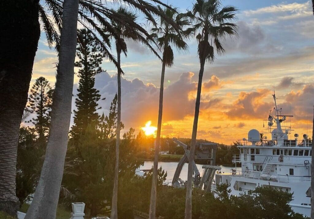 Sunset over harbor with research vessel.